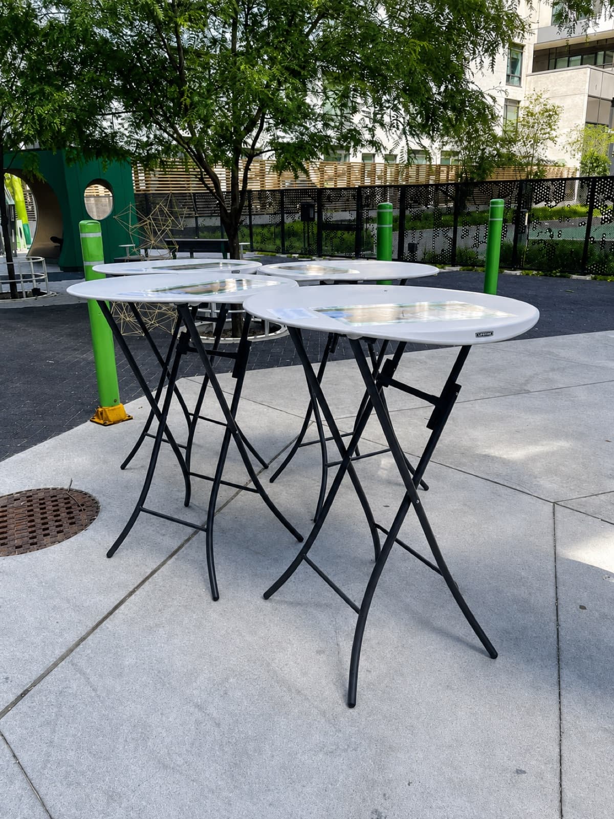 Matched set of 4 cocktail tables, outdoors, natural light