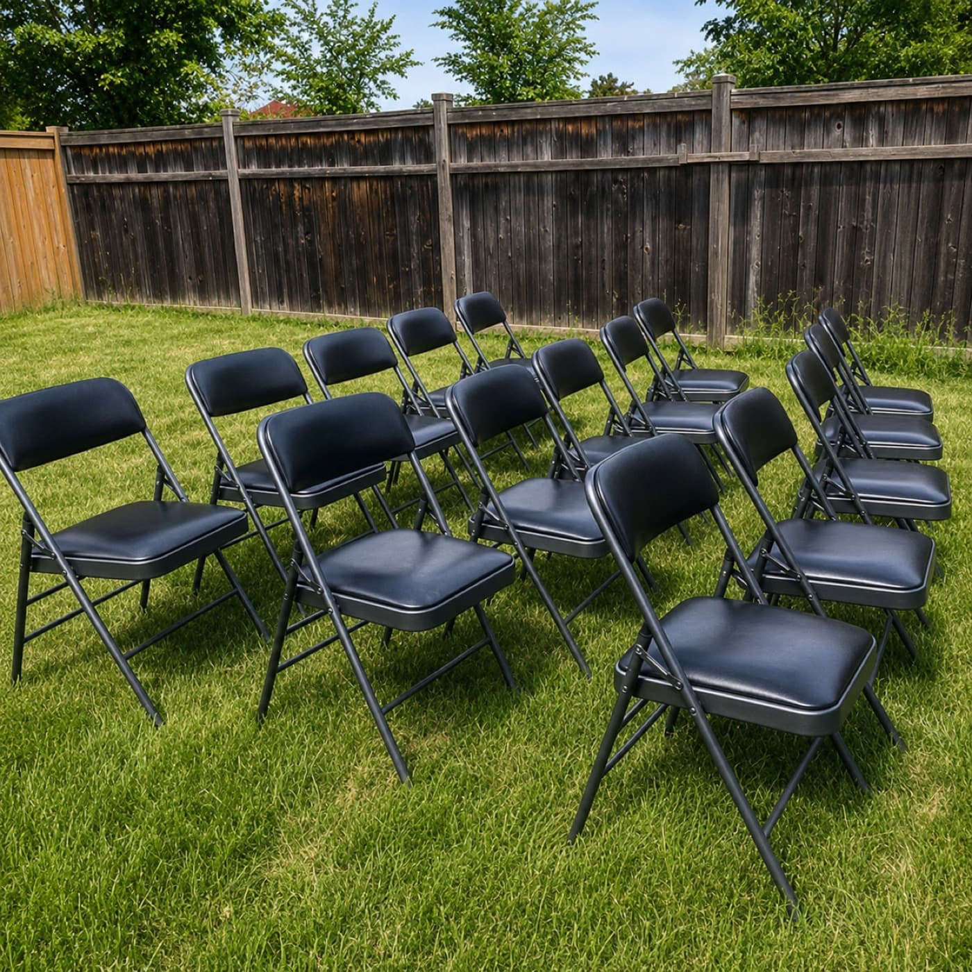 Matched black padded folding chairs set up outdoors